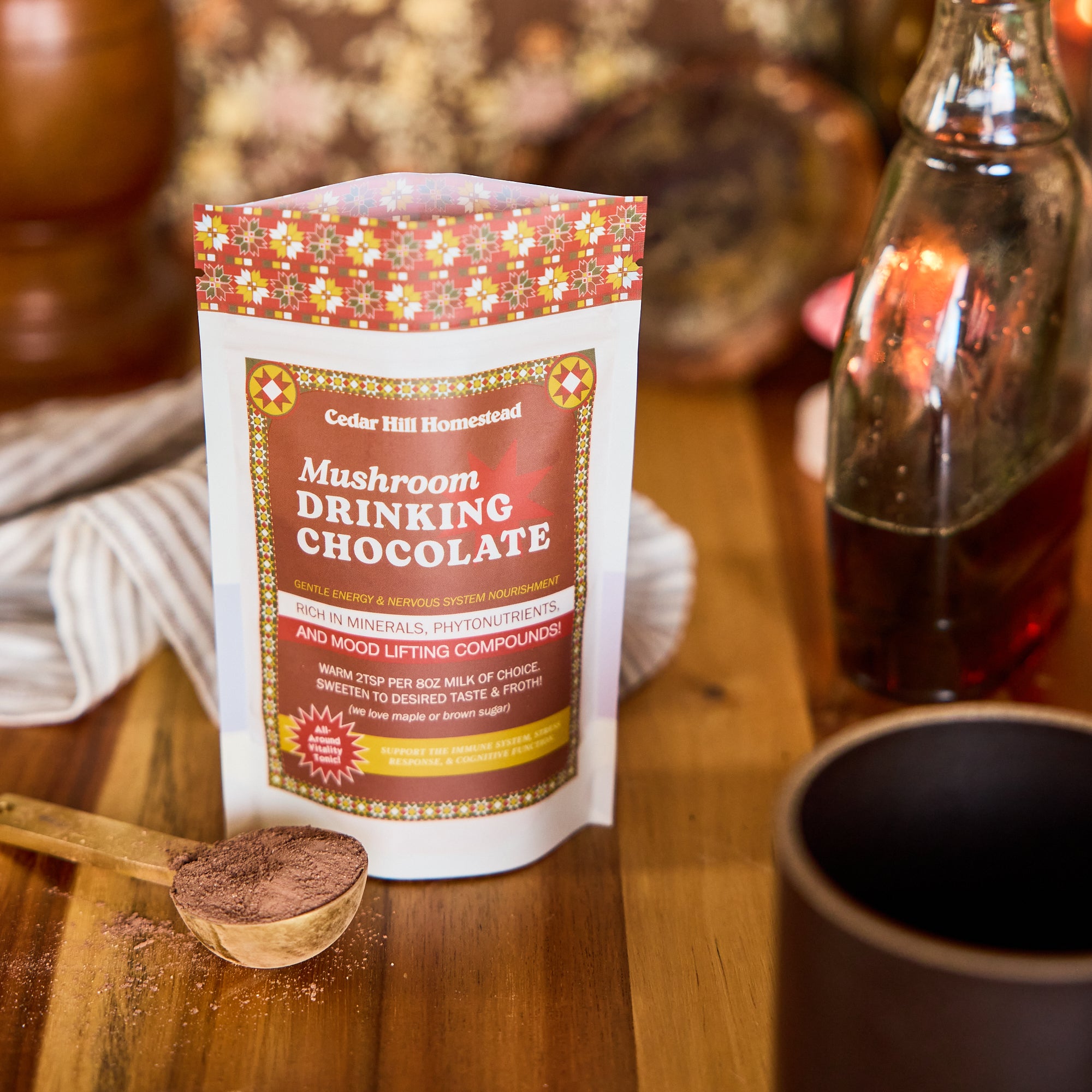 Mushroom drinking chocolate powdered drink mix on a wooden surface with a cup and spoon.